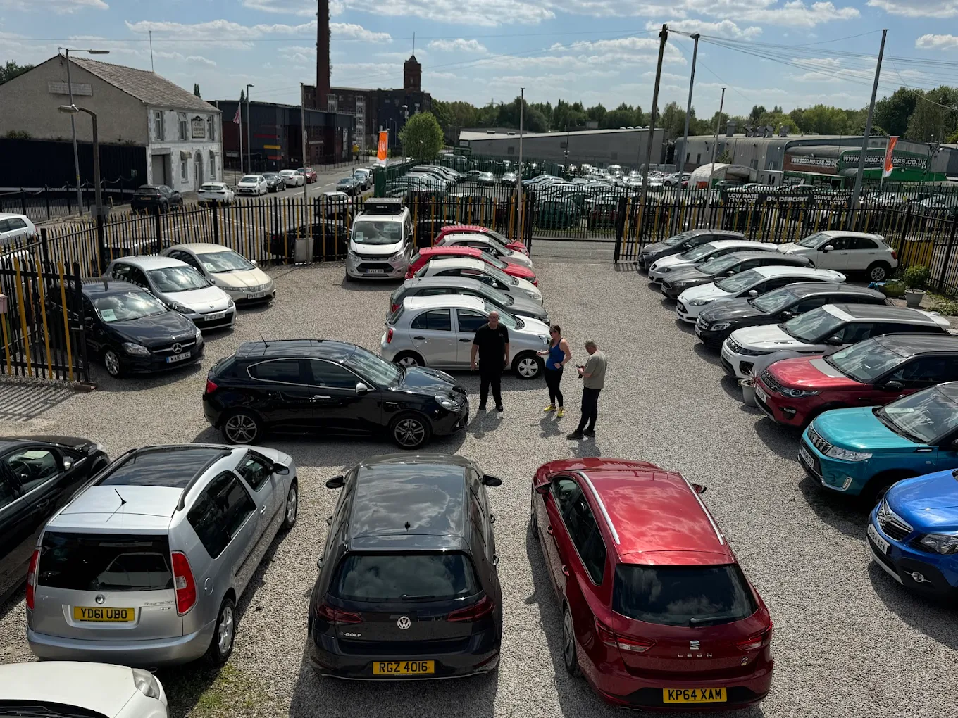 a group of people standing in a parking lot with cars